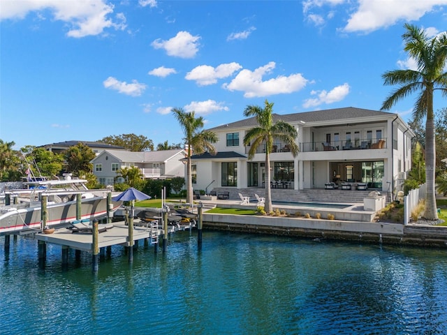 back of house featuring a patio, a balcony, and a water view