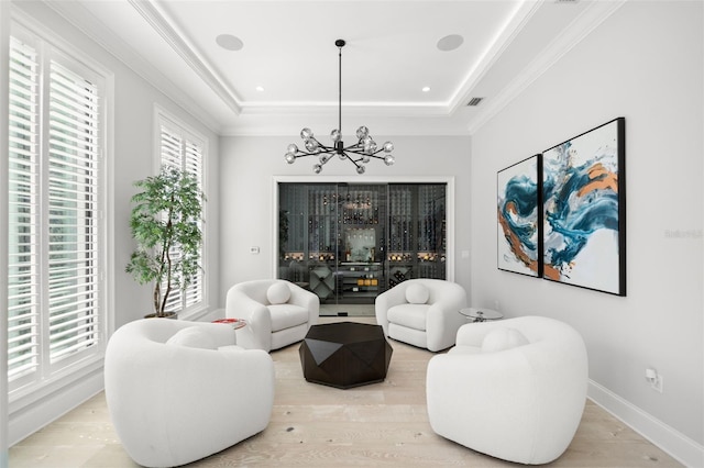 sitting room featuring a tray ceiling, crown molding, and light hardwood / wood-style flooring