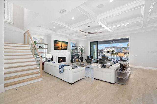 living room with beamed ceiling, coffered ceiling, and light hardwood / wood-style flooring