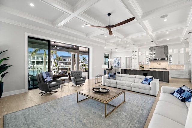 living room featuring ceiling fan, coffered ceiling, light hardwood / wood-style floors, and beam ceiling