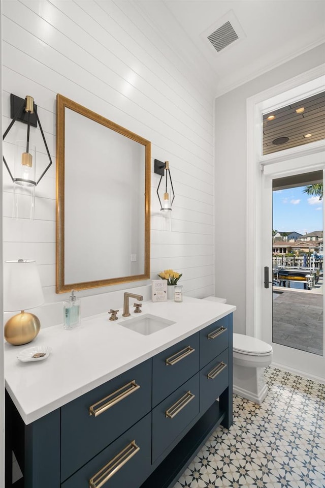 bathroom featuring vanity, crown molding, and toilet