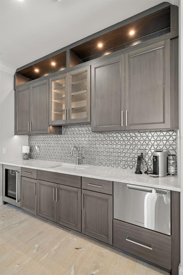 kitchen with sink, wine cooler, ornamental molding, decorative backsplash, and light wood-type flooring