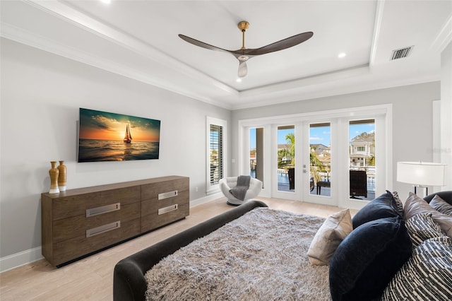 bedroom featuring access to exterior, ornamental molding, a raised ceiling, and french doors