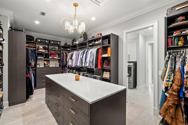 walk in closet with a notable chandelier and light wood-type flooring