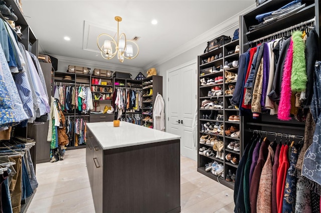 spacious closet featuring light hardwood / wood-style flooring and a notable chandelier