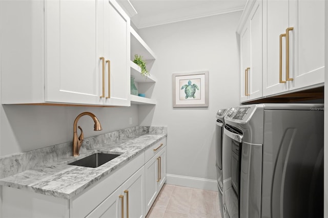 laundry room featuring sink, crown molding, washer and clothes dryer, light tile patterned floors, and cabinets