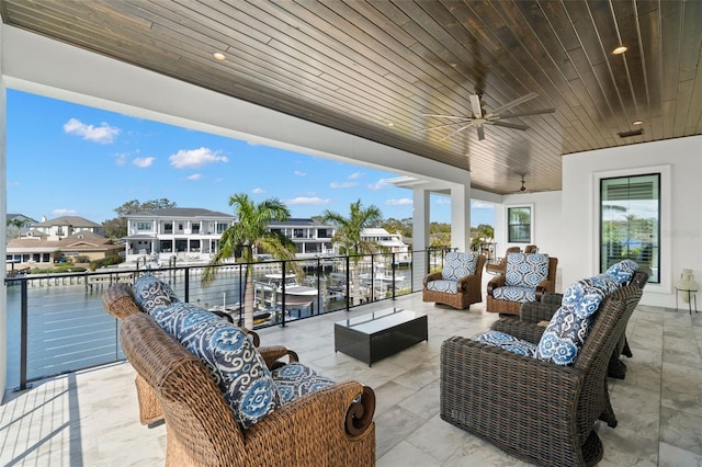 view of patio with a water view, an outdoor hangout area, and ceiling fan