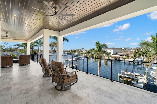 view of patio featuring a water view, ceiling fan, and a balcony