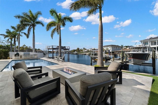 view of swimming pool featuring a water view, area for grilling, an outdoor fire pit, and a dock