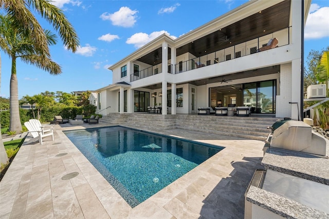 rear view of house featuring a patio, a balcony, cooling unit, exterior kitchen, and ceiling fan