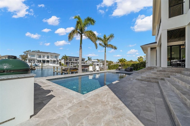 view of swimming pool with a patio and a water view