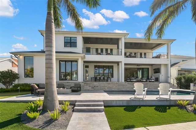 back of house featuring a patio area, a balcony, a yard, outdoor lounge area, and ceiling fan