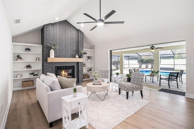 living room with wood-type flooring, a brick fireplace, and built in features