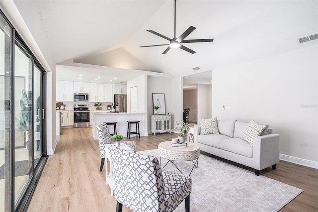 living room featuring ceiling fan, a healthy amount of sunlight, and light hardwood / wood-style flooring