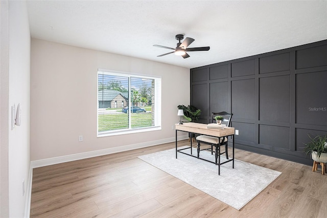 home office with ceiling fan, light hardwood / wood-style flooring, and a textured ceiling