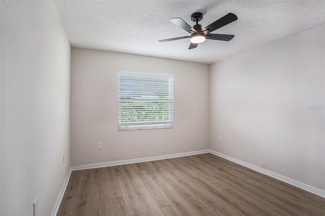 spare room featuring ceiling fan, light hardwood / wood-style flooring, and a textured ceiling