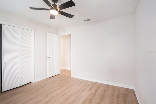 unfurnished bedroom featuring ceiling fan, a closet, and light hardwood / wood-style flooring