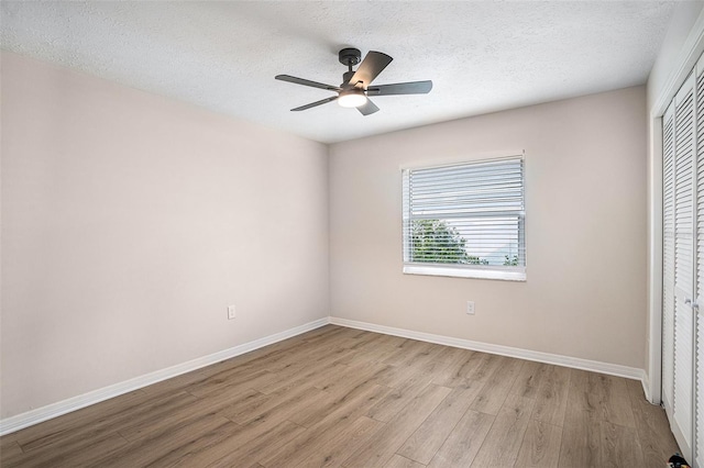 unfurnished bedroom featuring ceiling fan, a textured ceiling, a closet, and light hardwood / wood-style flooring