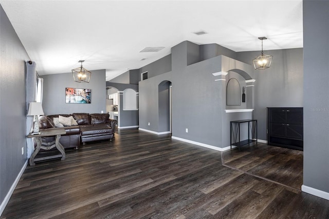 living room with lofted ceiling, dark hardwood / wood-style floors, and a notable chandelier