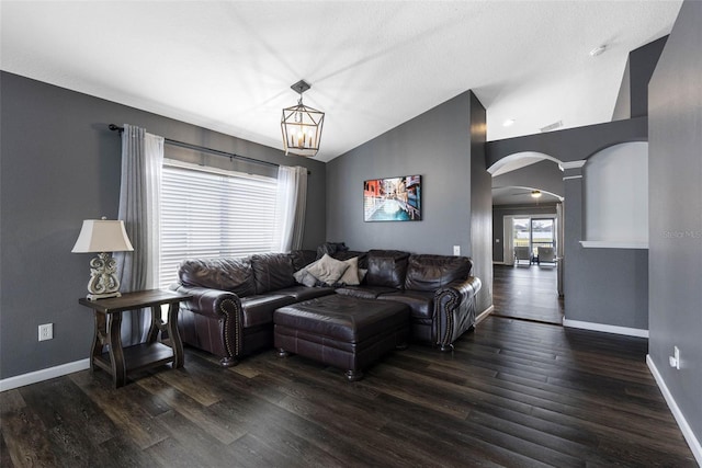 living room featuring an inviting chandelier, dark hardwood / wood-style flooring, and vaulted ceiling