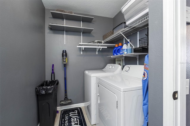 washroom with a textured ceiling and independent washer and dryer