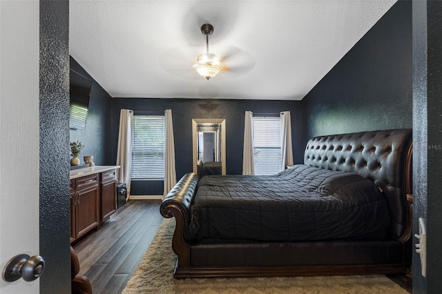 bedroom with ceiling fan and dark hardwood / wood-style flooring