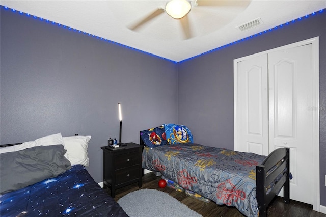 bedroom featuring dark wood-type flooring, a closet, and ceiling fan