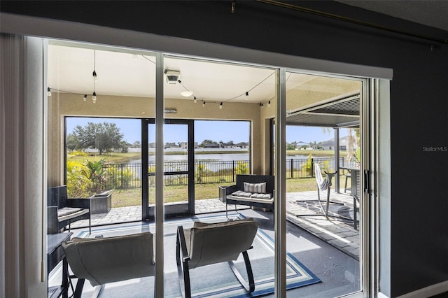 doorway to outside with a water view and track lighting