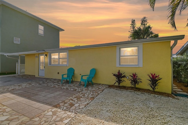 back house at dusk with a patio