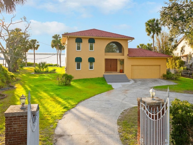 mediterranean / spanish-style house with a garage, a front yard, and a water view