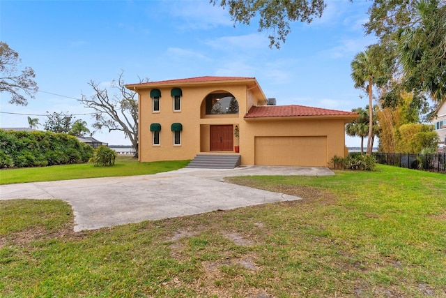 mediterranean / spanish-style house featuring a garage and a front yard