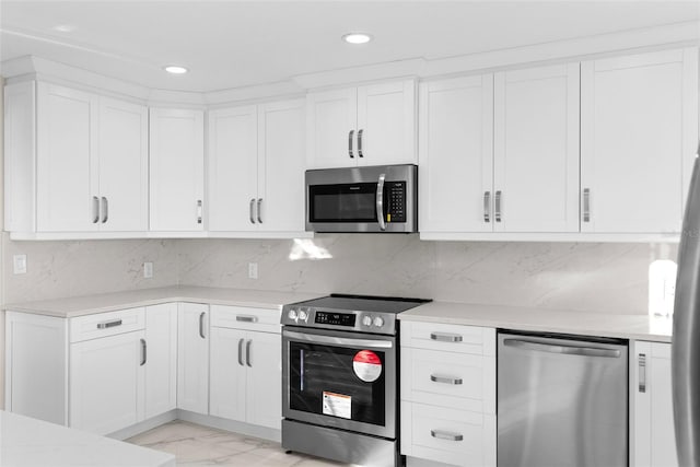 kitchen featuring white cabinetry, appliances with stainless steel finishes, and decorative backsplash