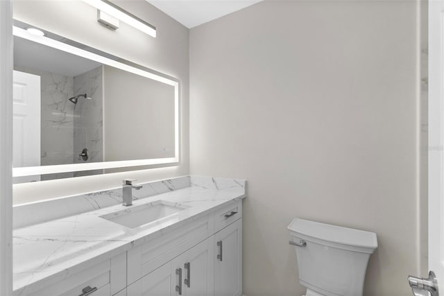 bathroom featuring vanity, toilet, and a tile shower