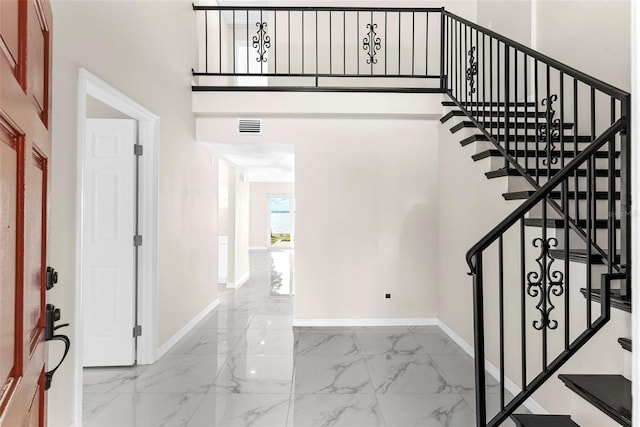 entryway with marble finish floor, baseboards, and visible vents