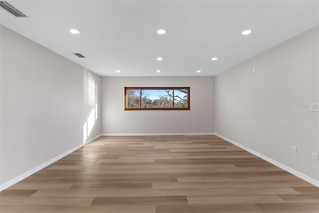 unfurnished room featuring light wood-style floors, baseboards, visible vents, and recessed lighting