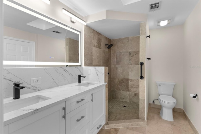 bathroom featuring a tile shower, a sink, visible vents, and decorative backsplash