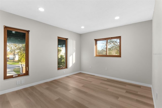 empty room featuring recessed lighting, light wood-type flooring, and baseboards