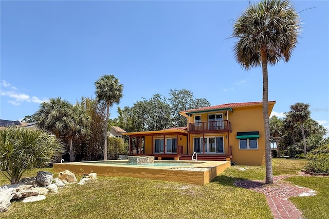 316 Shore Dr E, Oldsmar, FL 34677 - back of house featuring a lawn, stucco siding, and a balcony