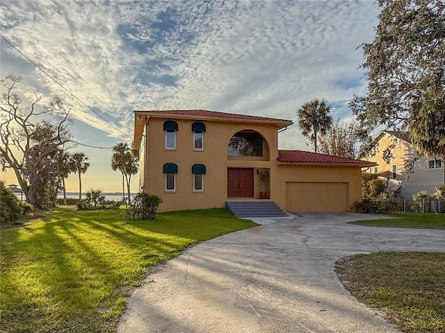 316 Shore Dr E, Oldsmar, FL 34677 - view of front of house featuring stucco siding, a garage, a front lawn, and aphalt driveway