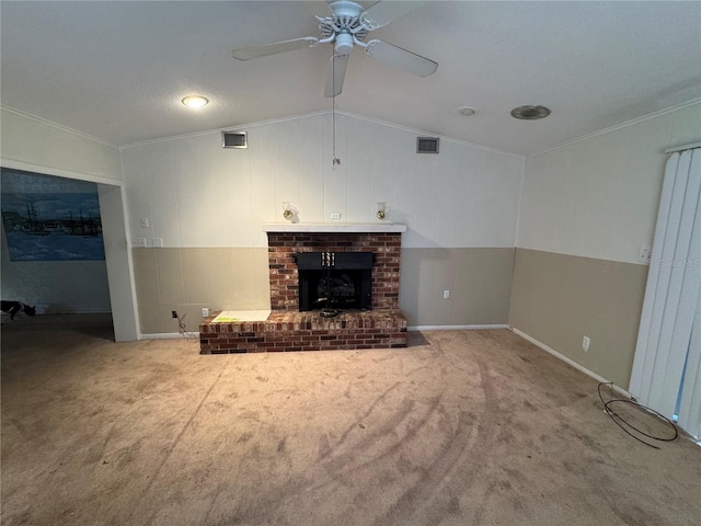 unfurnished living room featuring vaulted ceiling, carpet floors, ornamental molding, ceiling fan, and a brick fireplace