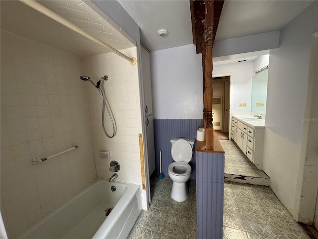 full bathroom featuring vanity, tiled shower / bath, and toilet