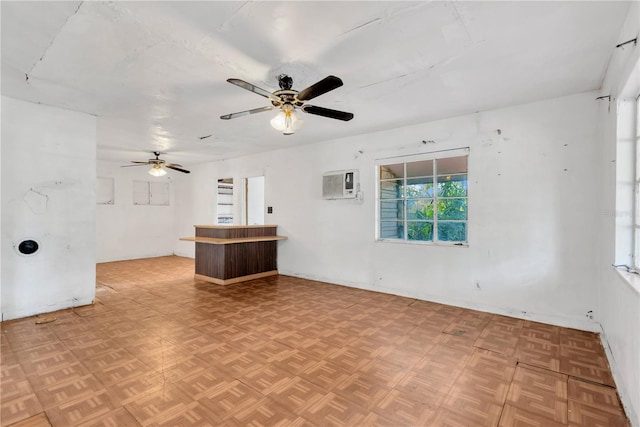 unfurnished living room with a wall mounted air conditioner, light parquet floors, and ceiling fan