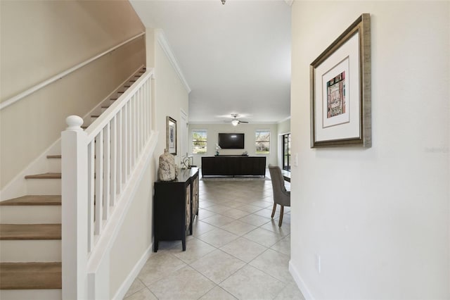 stairway featuring tile patterned flooring, crown molding, and ceiling fan