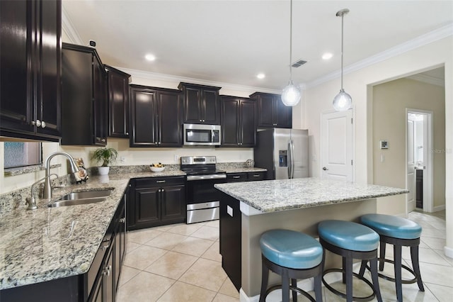 kitchen with stainless steel appliances, decorative light fixtures, a center island, and sink