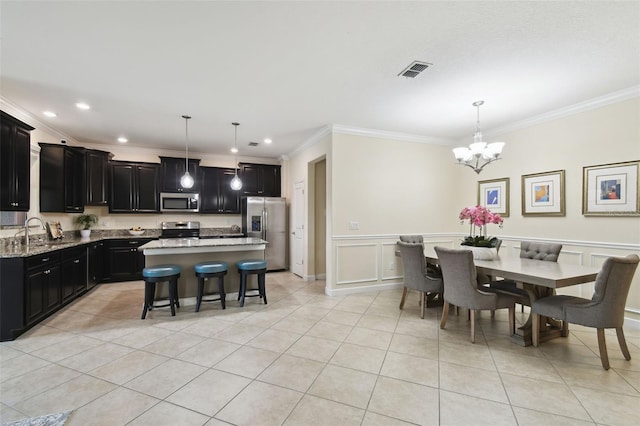 dining room featuring crown molding, sink, light tile patterned floors, and an inviting chandelier