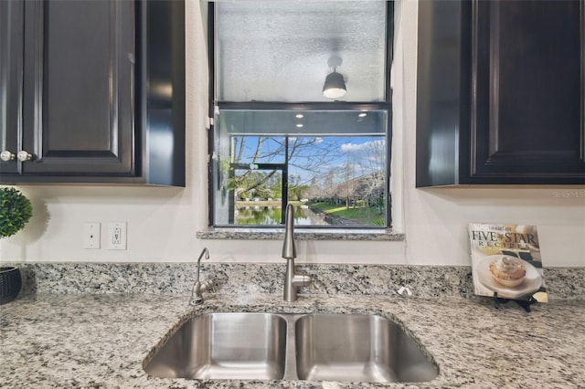 details featuring light stone countertops and sink