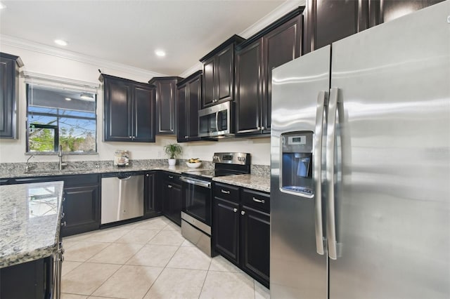 kitchen featuring sink, light tile patterned floors, ornamental molding, appliances with stainless steel finishes, and light stone countertops