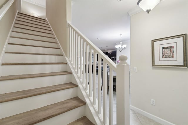 staircase with tile patterned floors and an inviting chandelier