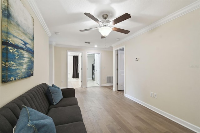 living room featuring ornamental molding, light hardwood / wood-style floors, and ceiling fan