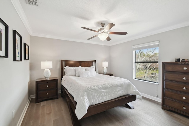 bedroom with crown molding, ceiling fan, and light hardwood / wood-style floors